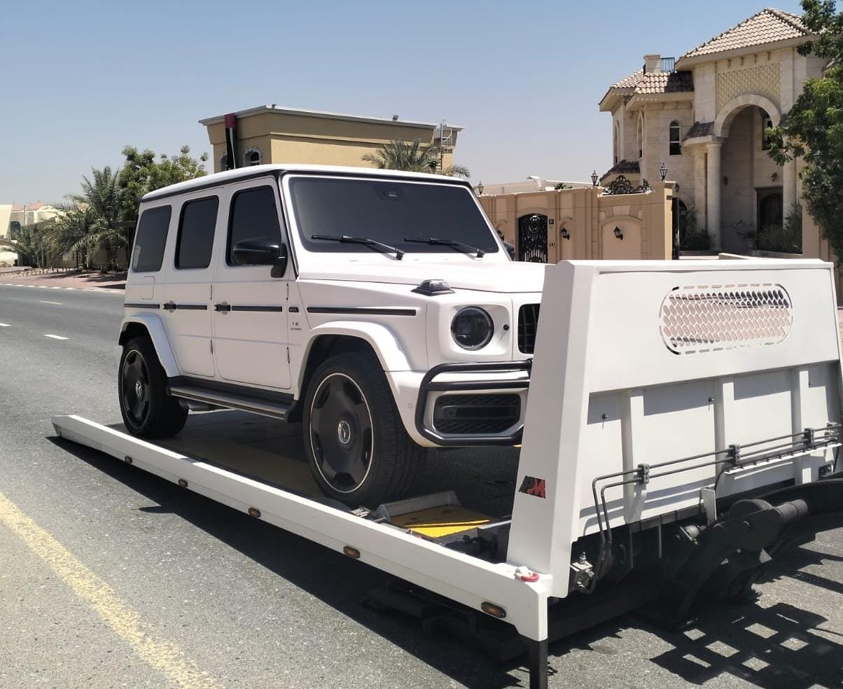 Vehicle strapped down on a flatbed tow truck in Dubai